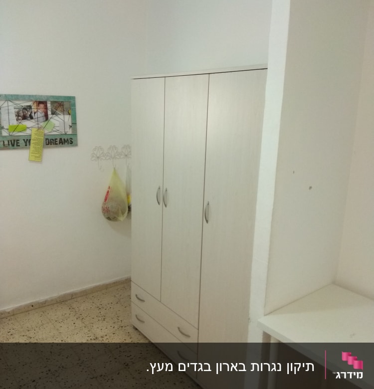 ארון בגדים עם ידיות מתכת בחדר